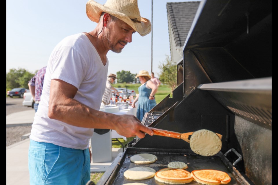Jason Spence flips pancakes for a Stampede Breakfast at the Okotoks Alliance Church on July 9. (Brent Calver/Western Wheel File Photo)