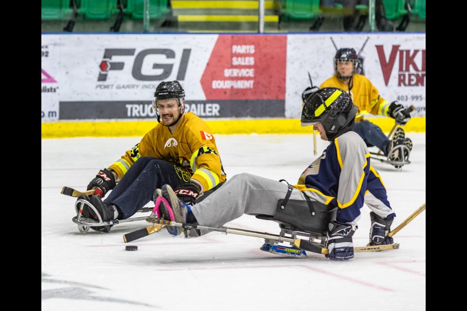 Members of Okotoks Fire and Rescue and High River Fire Department compete in a friendly sledge hockey scrimmage for an exhibition event held by the Cederstrand Foundation at Okotoks Centennial Arenas on Nov. 25, 2023.