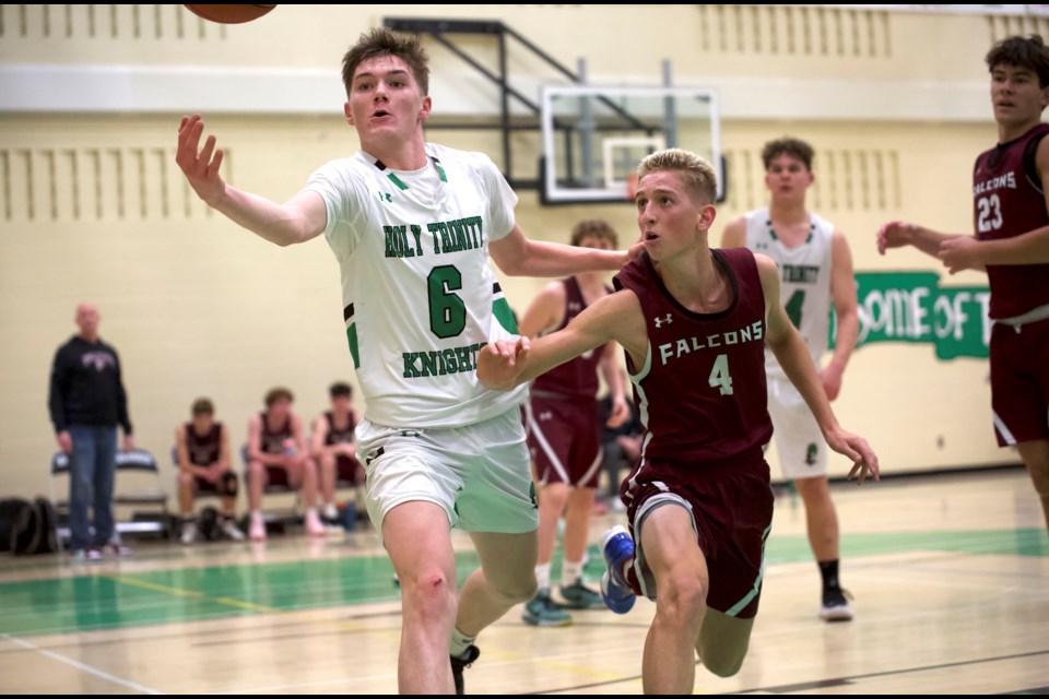 HTA Knights forward Isaac Hogan and Foothills Falcons guard Nash Byam battle for a rebound during the senior boys basketball clash on  Dec. 10 at HTA. The Falcons won by a 76-67 score.