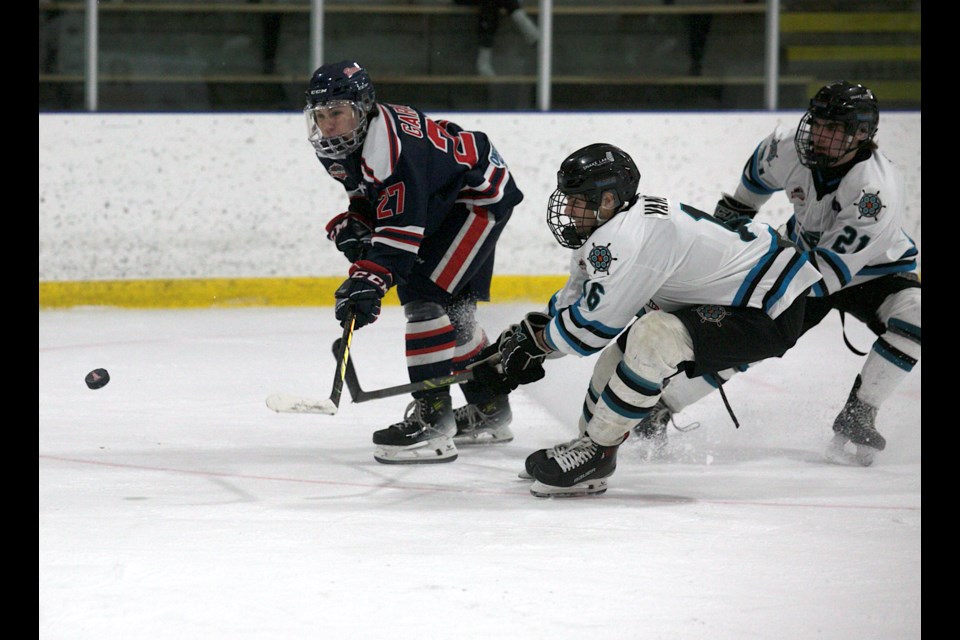 Carstar Okotoks Bisons forward Seamus Garagan lifts a backhand shot on goal with Sylvan Lake Wranglers Justin Vandermeer and Owen Callow defending during Okotoks’ 6-1 win on Feb. 10 at Murray Arena. 