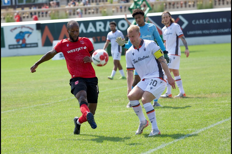 Cavalry FC striker Malcolm Shaw chases down a clearance from Forge FC captain Kyle Bekker during the Canadian Premier League match on July 21 at Spruce Meadows’ ATCO Field. The teams played to a 1-1 draw.