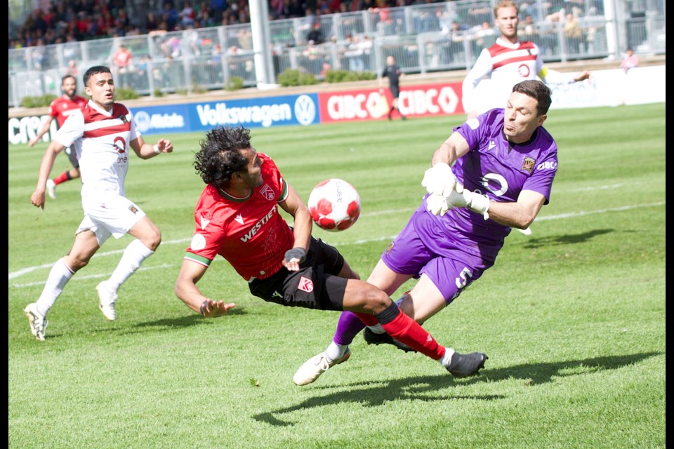 Cavalry FC midfielder Shamit Shome collides with Valour FC goalkeeper Jonathan Viscosi during the 1-1 draw in Canadian Premier League action on May 26 at Spruce Meadows’ ATCO Field.