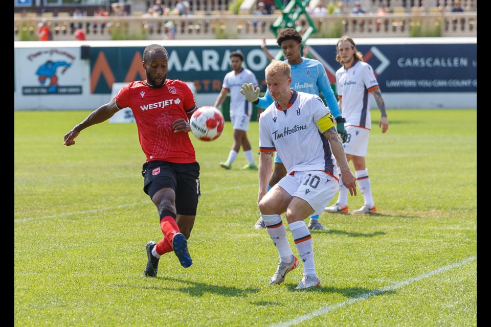 Cavalry FC striker Malcolm Shaw battles with Forge FC captain Kyle Bekker defending during 2024 CPL regular season action.