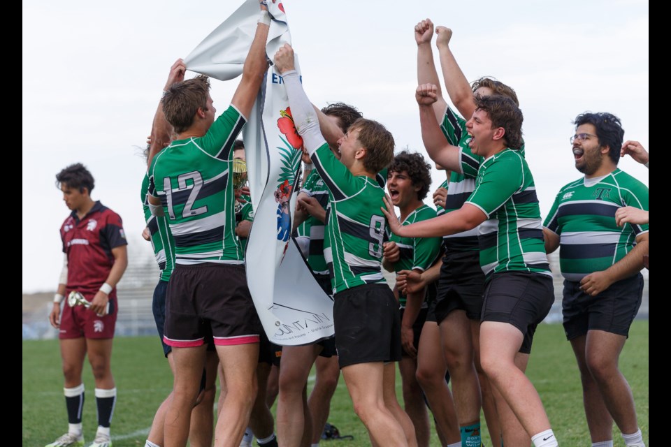 The Holy Trinity Academy Knights celebrate with the banner after winning the senior boys division title at the Clearwater Cup rugby sevens tournament on May 11 at the Calgary Rugby Union. HTA defeated Henry Wise Wood 40-0 in the final.