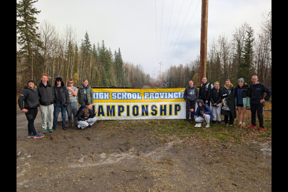 The Holy Trinity Academy Knights' 11 provincial athletes stand on the track alongside coaches Paula Paulgaard and Bruce Dickie.