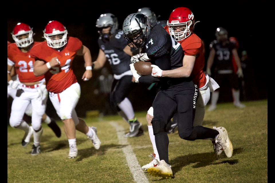 Holy Trinity Academy Knights runningback Lincoln Stewart charges forward in the high school football clash versus the Raymond Comets on Oct. 17 at Knights field in Okotoks. The Comets won by a 47-25 score. 