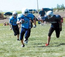 A Foothiils Eagle runs for daylight at the team&#8217;s Bantam Football Camp on Aug. 20 at Holy Trinity Academy.