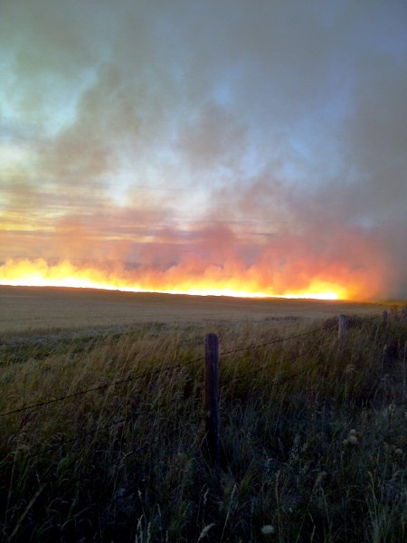 A fire lights up the night sky south of Okotoks on Sept. 29. The grass fire burned through the night as firefighters battled to keep it contained.