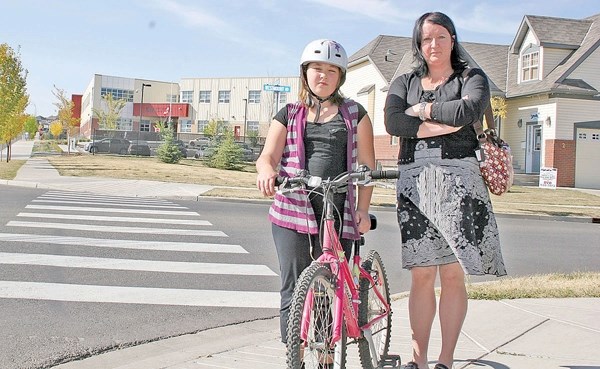 Emma and Krista Percey at the crosswalk where Emma was struck by a truck near Westmount School in Okotoks.