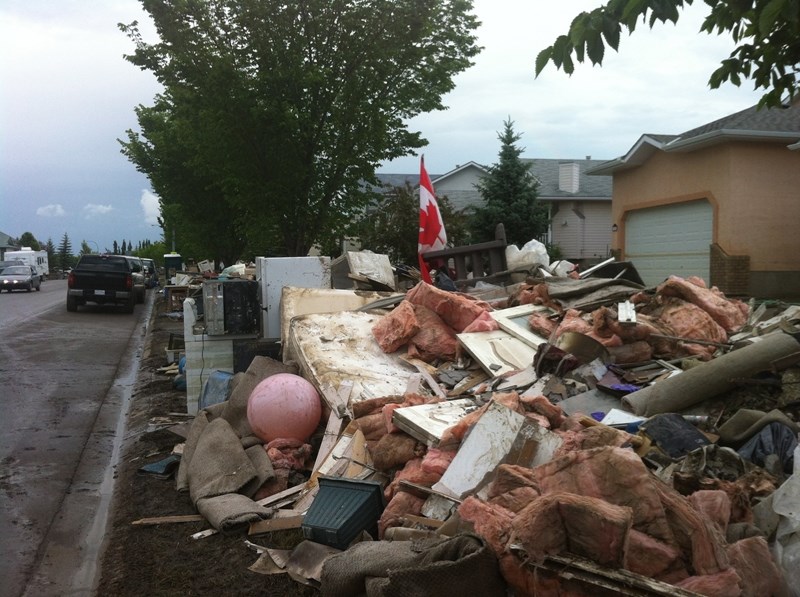 Garbage is piled in front of a home in High River last weekend. More than 25,000 tonnes of garbage has been taken to the Foothills Regional Landfill since the June flood.