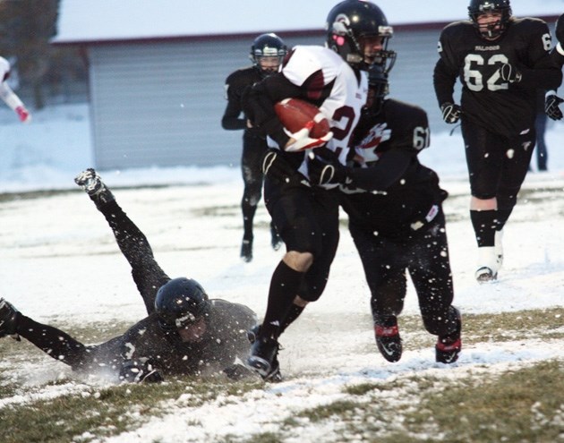 Foothills Falcons Garrett Young (3) and Ryan Cole (61) try to wrap up Rundle College Cobra Noah Muruve in the Big Rock Conference final last year, won by the Cobras. The two