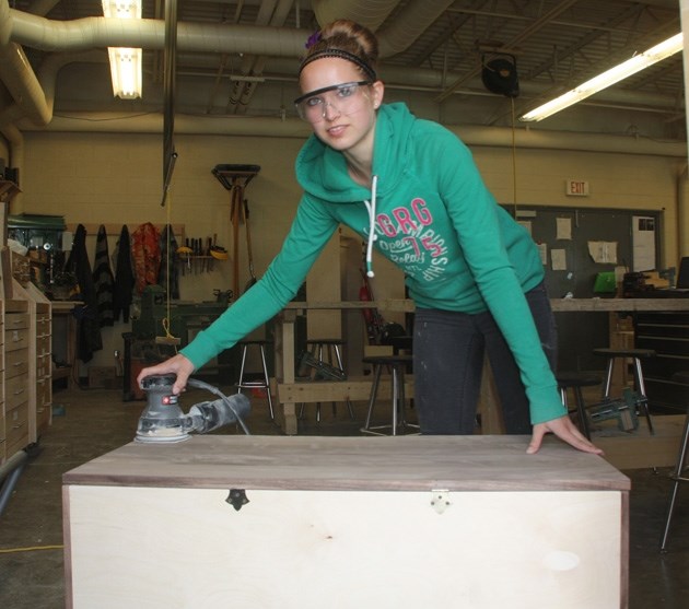 Madison McArdle sands her workbench which she made in the construction class at Holy Trinity Academy. McArdle has found the time to be an honour student in HTA advanced