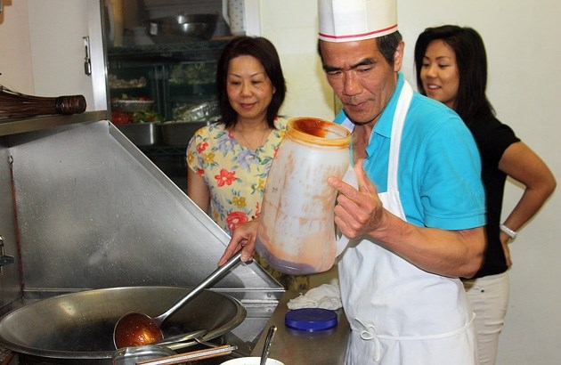 Joe Seto prepares a dish of Thai chicken at the Golden National Family Restaurant. He is joined by daughter Amanda Seto and wife and Golden National co-owner Judy Seto.