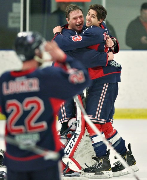 Okotoks Bisons goaltender Brayden Engel embraces forward Phil Dillon after the Bisons clinched their record fourth consecutive Heritage Junior Hockey League championship in a 