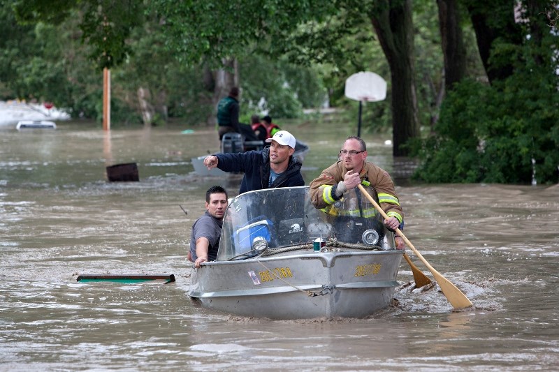 Residents make their way through a flooded High River in June 2013. The MD is creating new flood maps after a number of mitigation efforts were build along the Highwood River 