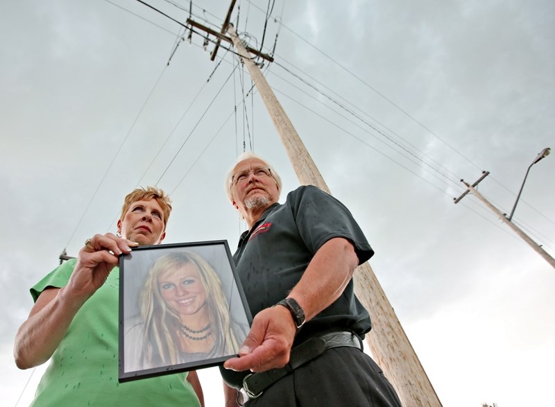 Ed and Deb Sands hold a portrait of their daughter Amy who was shot and killed in Calgary.