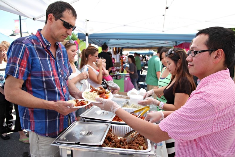 Joey Favrigar hands out Chinese food dishes at the Big Rock Inn booth during the Taste of Okotoks in 2013. This year&#8217; s event takes place on July 25.