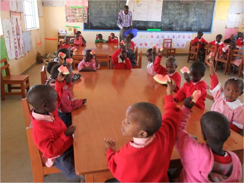 Children raise their hands in a classroom at the Building Hope Academy in Kenya. The school was built thanks to work by an initiative began by students at Red Deer Lake