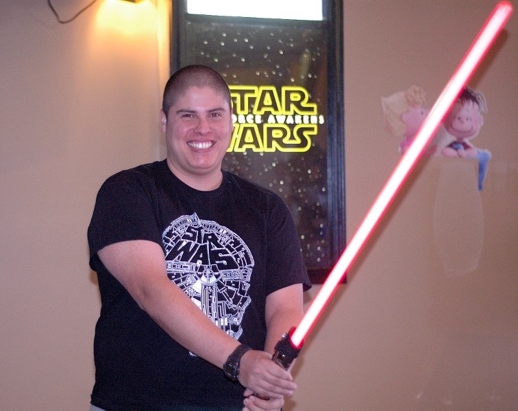 Okotoks resident Eleazer Salazar holds up a light sabre in anticipation of the opening of Star Wars: The Force Awakens. As of Dec. 14, the Okotoks Cinemas still had tickets