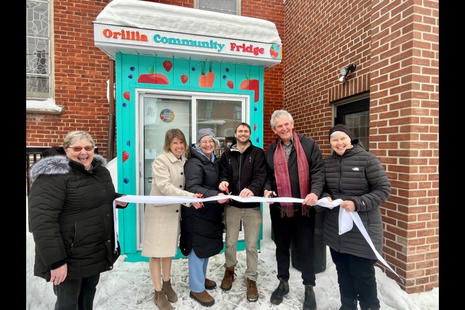 Members of the planning team, along with St. Paul's minister Ted Reeve and Coun. Jay Fallis, gather to cut the ribbon at the grand opening of the Orillia Community Fridge.