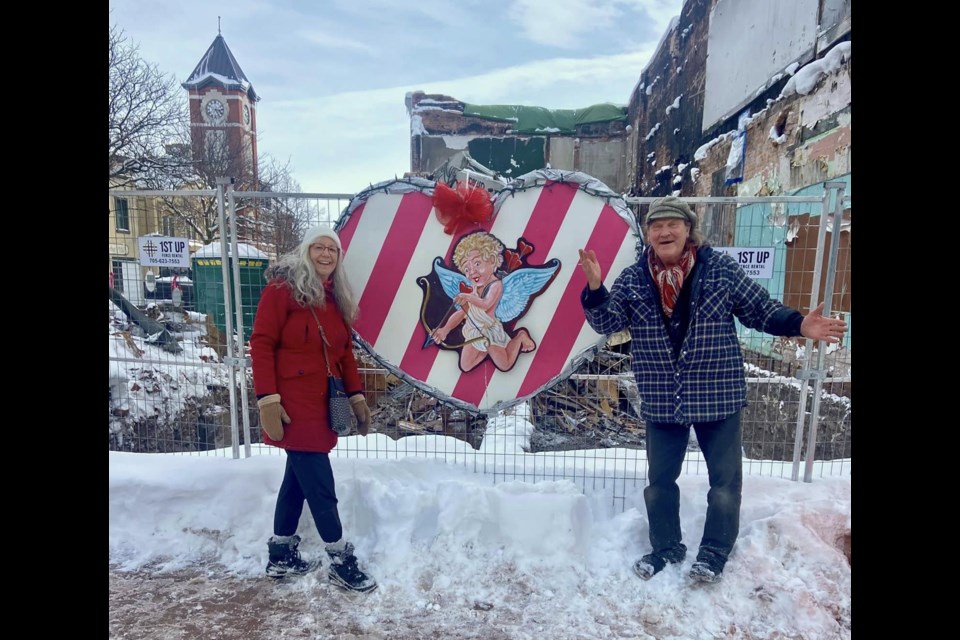 Leslie Fournier and Paul Baxter are showing love to the Peter Street Arts District after decorating the fence around the site destroyed by fire last month.