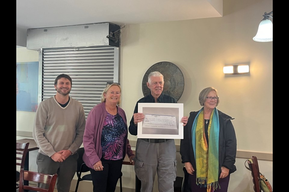 Councillor Jay Fallis, Betty Fallis, and Minister Patti Rodgers hand a cheque to past Hillcrest Lodge president Mike Jones.