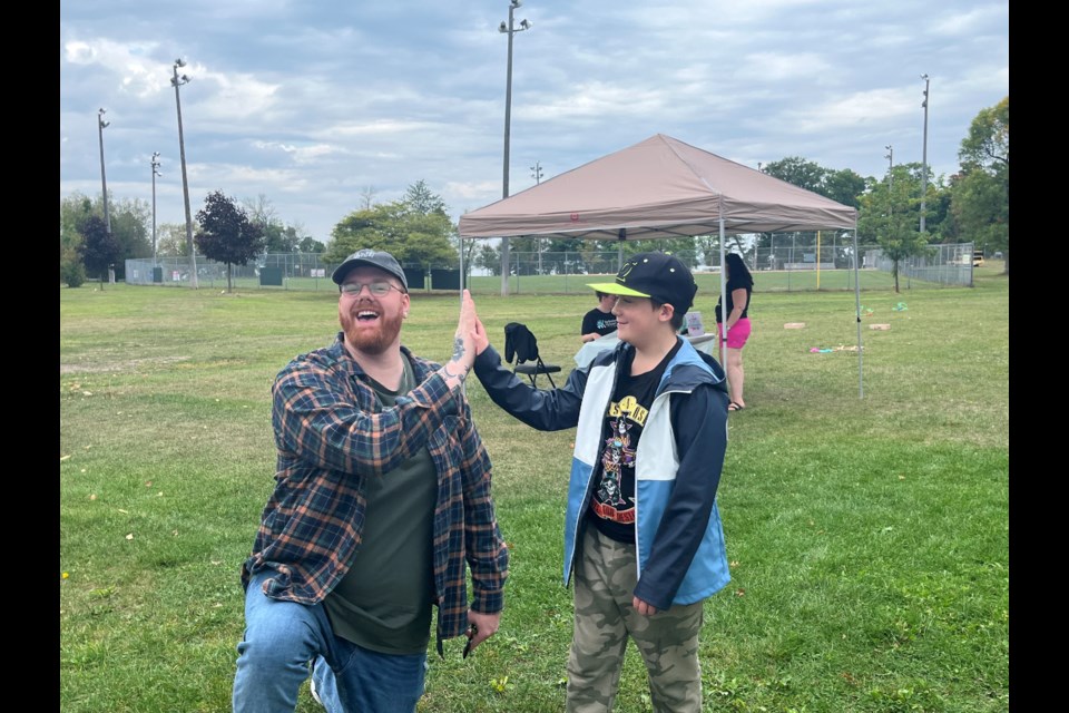 Big Brother Dave Ward and his little brother high five at the Big Barbecue Saturday. The event was held to appreciate volunteers; it also marked their first year as a match.