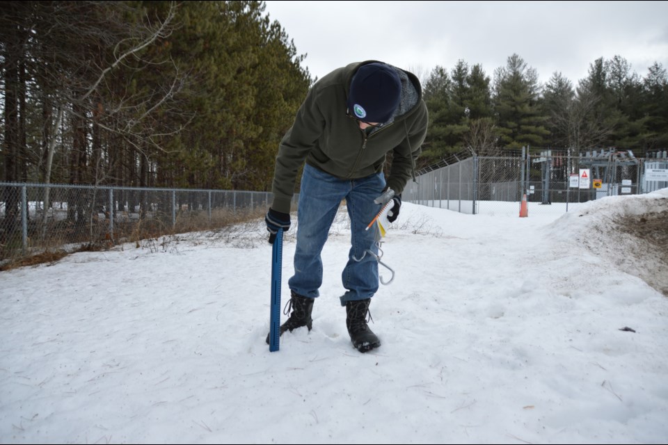 A Nottawasaga Valley Conservation Authority flood specialist collects samples from a snowpack.