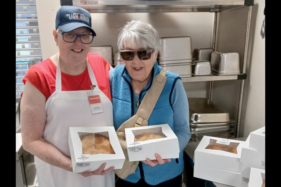 A volunteer and a donor are shown with 10 pies from Country Produce for Thanksgiving dinner at The Lighthouse.