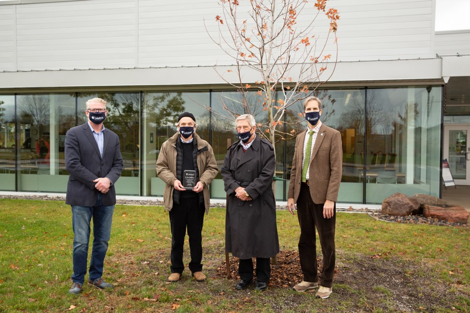 City of Orillia Mayor Steve Clarke, former Orillia mayor Ron Stevens, and Dr. Dean Jobin-Bevans are pictured with Dr. Kim Fedderson (second from left) at the tree planted in his honour on the Orillia campus. Supplied photo