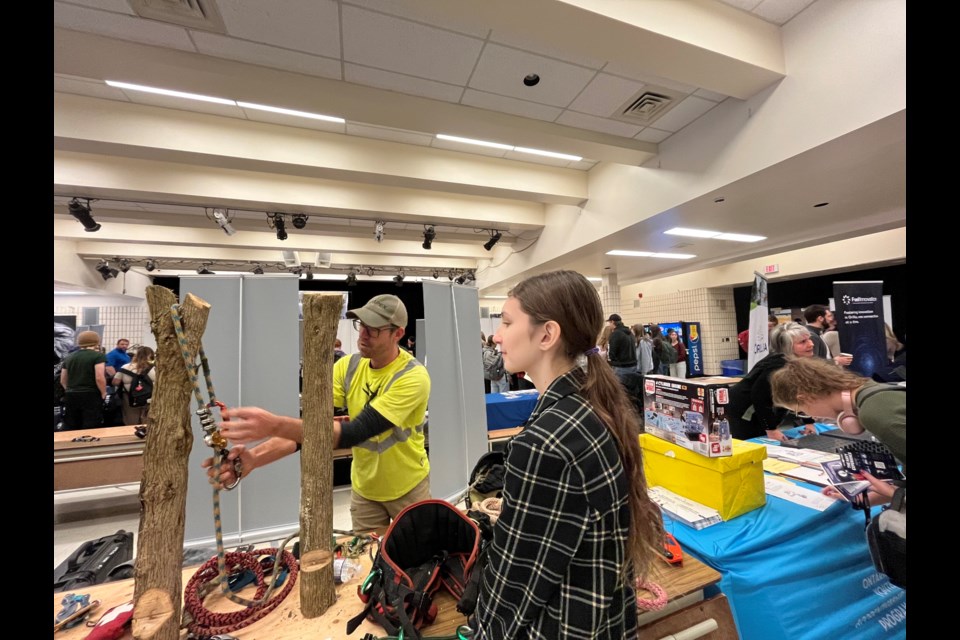 Adam Gutowsky shows Ava Mederak the equipment he uses working for Apex Tree Surgeons during the Tech Expo on Wednesday at Twin Lakes Secondary School in Orillia.