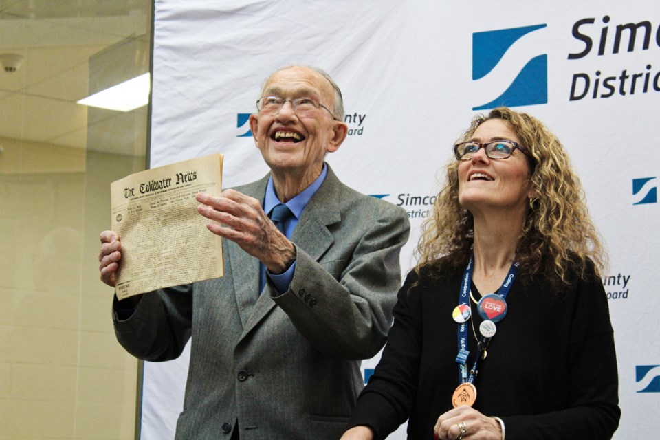 Former principal Ken Hammond holds a copy of the Coldwater News on Friday at Orillia Secondary School. Hammond and Simcoe County District School Board chair Jodi Lloyd revealed the contents of a time capsule from 1949 that was tucked into a cornerstone at the former Orillia District Collegiate and Vocational Institute. Nathan Taylor/OrilliaMatters