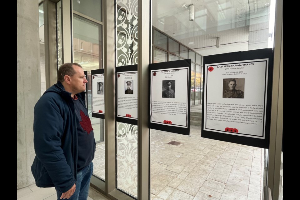 Robert Huften reads the stories of soldiers, on display at the Orillia Public Library since October, for its annual Remembrance event.