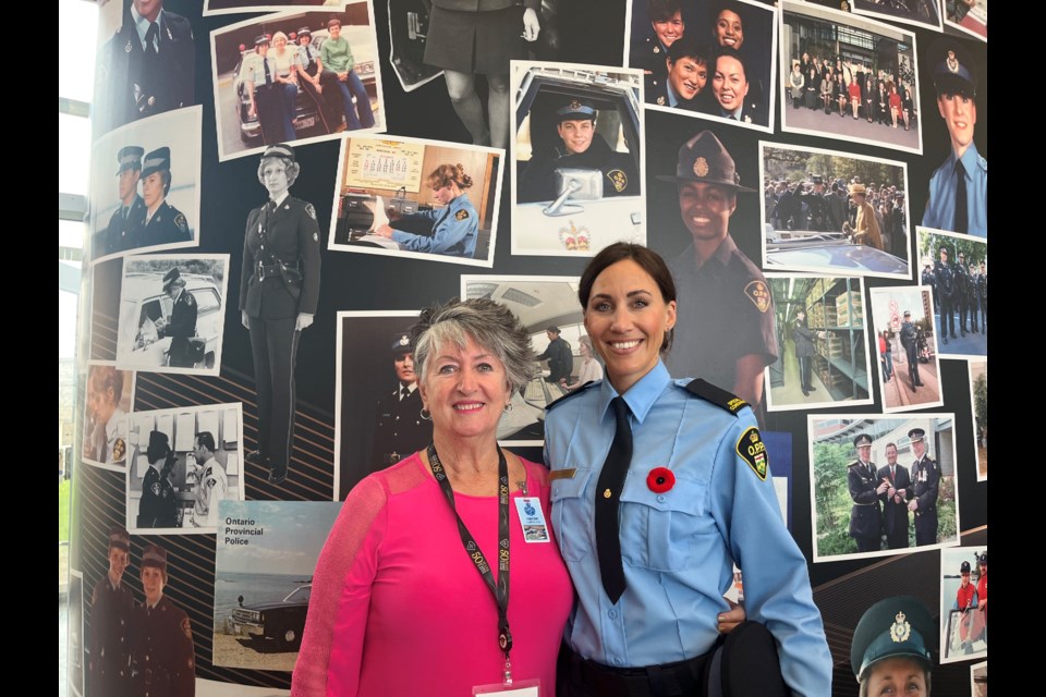 Retired inspector Irena Lawrenson of Orillia and her step-granddaughter, Nicole Donaldson, are shown in front of a mural celebrating 50 years of women in uniform at OPP General Headquarters on Wednesday. Lawrenson was among the first female officers hired by the OPP in 1974.