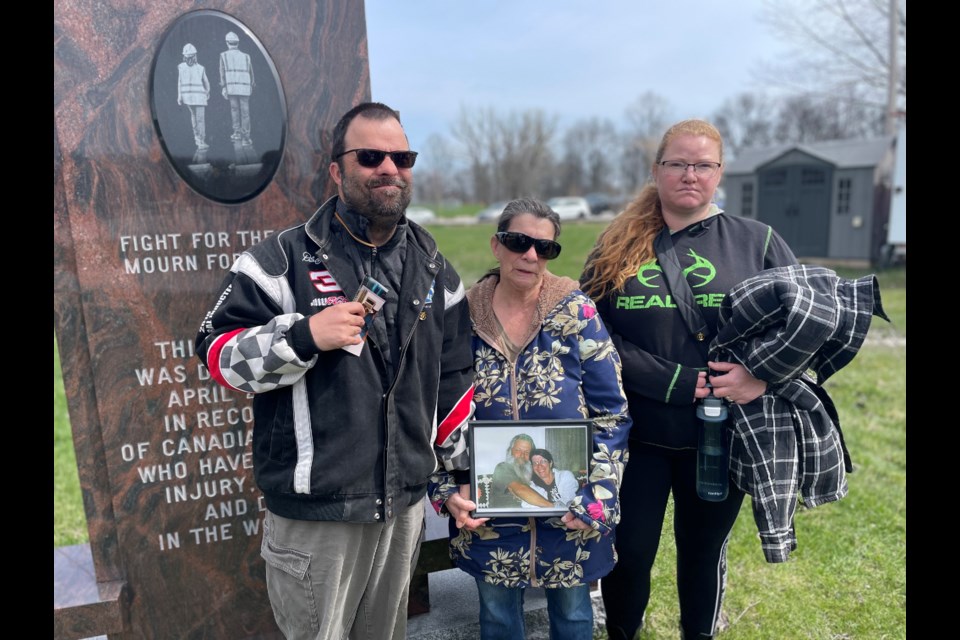 From left, Tommy Post, Sharon Post, and Fawn LeClair are shown at Friday's Worker's Day of Mourning at Tudhope Park. They were there to honour their stepfather, fiancè, and friend, Wayne Taylor, who was killed in a workplace accident in Hawkestone in 2007.