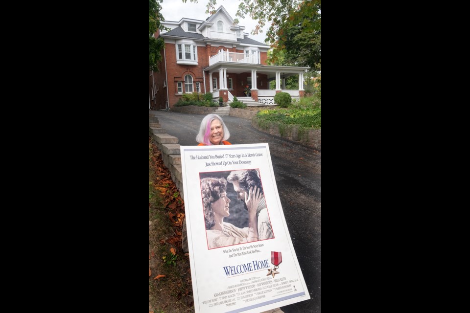 Pat Hehn poses with the movie poster that still graces her upstairs hallway in her home just down from the filming location of 68 Tecumseth St. Her son, who was a paper boy at the time, also got to play one in the 1989 movie.