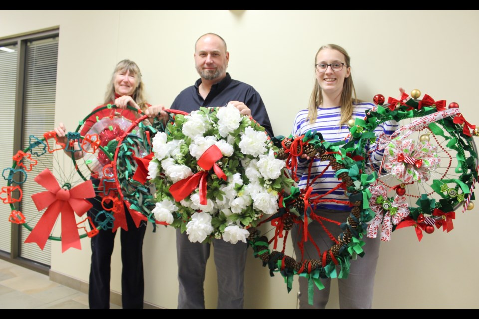 Students from Brechin Public School and Foley Catholic School created these wreaths for the inaugural Brechin Christmas Kick-Off, which will take place Dec. 3. Showing off the wreaths are, from left, Janet Johnson, secretary with Brechin and Beyond, Chris Robinson, Ramara Township's building inspector, and Sarah Carabin, administrative assistant. Nathan Taylor/OrilliaMatters