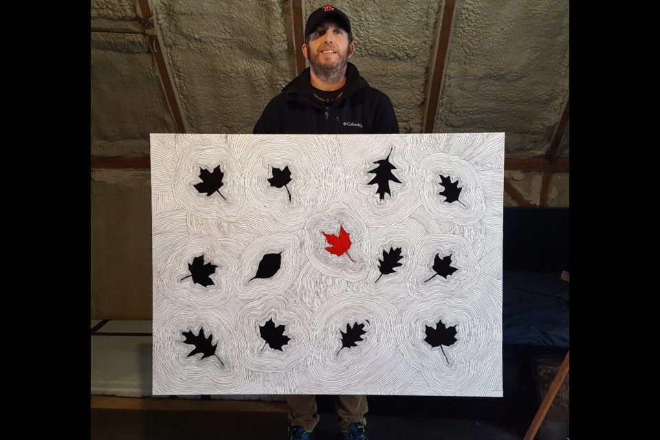 James Lightle is shown with one of his works of art.