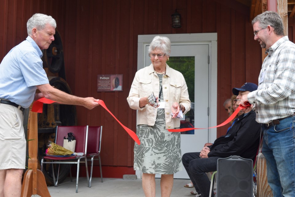 Gwen Robinson, chair of the Coldwater Mill Heritage Foundation, cuts the ribbon to officially open the second floor of the Coldwater Mill Museum.