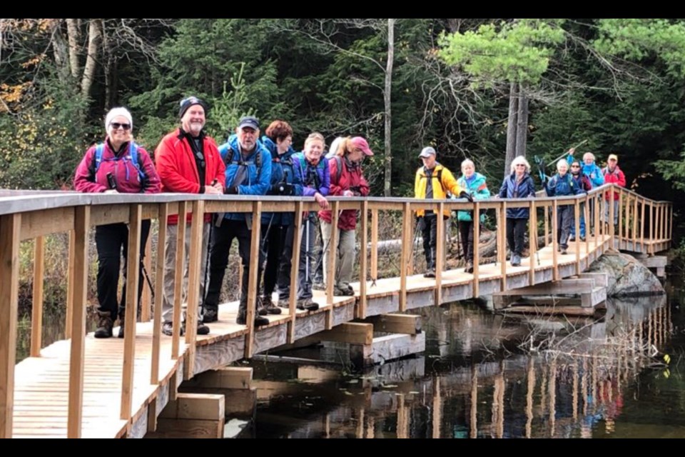 Members of the Orillia chapter of the Ganaraska Hiking Club gather for a group photo on the bridge during their Coopers Falls Trail hike.