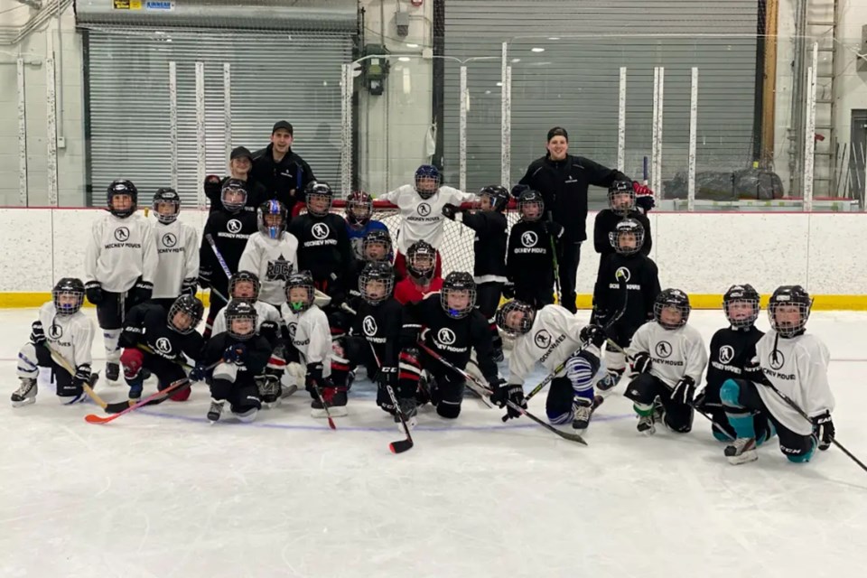 Paige McGuire, Hunter Godmere and Jake Mortley are shown with a group of campers at the end of a Hockey Moves program in Gravenhurst.