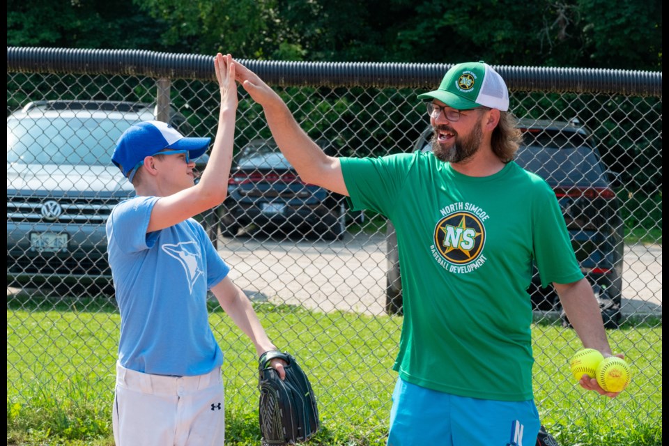 Max Weaver gives his coach, Joey Windsor, a high-five during Challenger Baseball on Saturday morning at Bayview Park in Orillia.