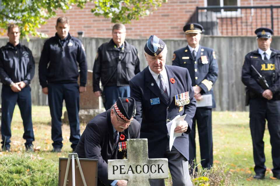 Dr. Garry Willard bends to place a wreath at the grave of Stanley Peacock at a grave-side ceremony Tuesday morning. Peacock, a 16-year-old electrician's apprentice, was killed when a Fairmile war ship, being constructed at Hunter Boats at Orillia's waterfront, exploded in October of 1943.