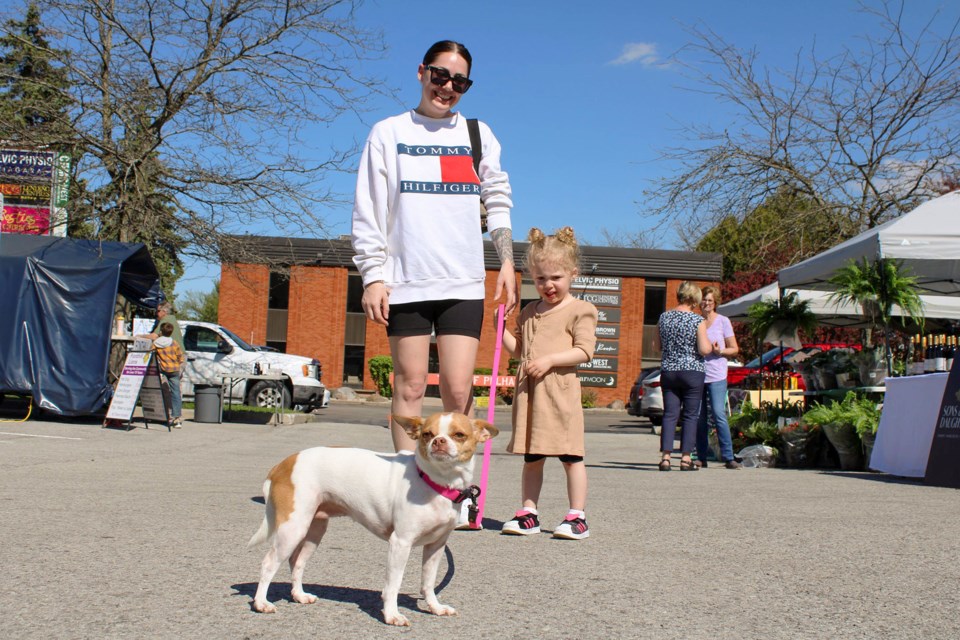 Layla, a pup belonging to Marsy, left, and Ava Slater, gets some fresh air on opening day at the Pelham Farmers' Market on Thursday.