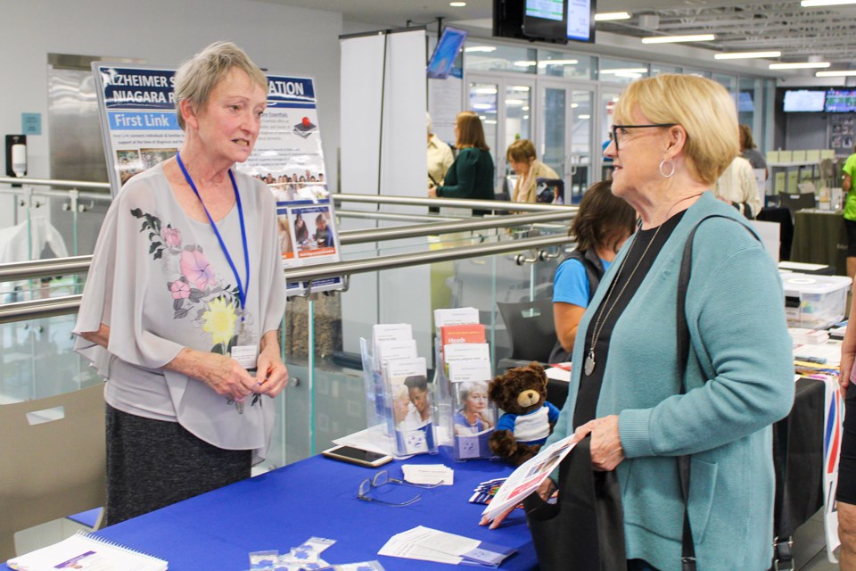 Elizabeth Narbonne, left, talks with Lynda Stahl about the services and programs that are offered by the Alzheimer’s Society of Niagara. The Alzheimer’s Society was one of 35 vendors taking part in the Town of Pelham’s Seniors Information and Active Living Fair at the Meridian Community Centre on Tuesday.