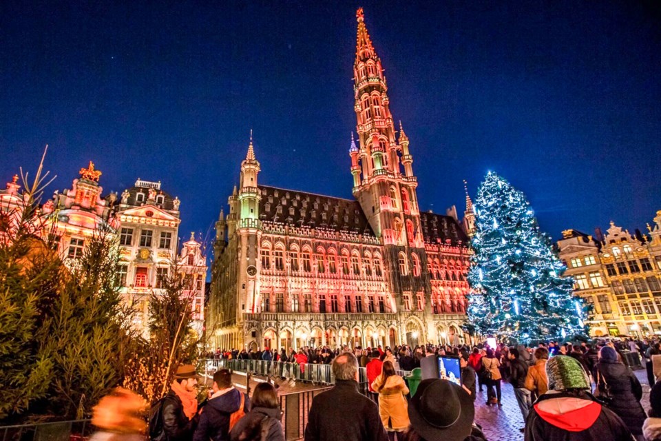 A 20-metre tall Christmas tree is bathed in lights, surrounded by 500 year old buildings of the Grand-Place in downtown Brussels.