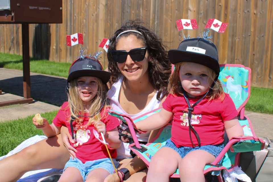 Aria Zaremba, left, her mom, Juliana, and sister, Alessia were anxiously awaiting the start of Pelham’s Canada Day Grand Parade on Monday.