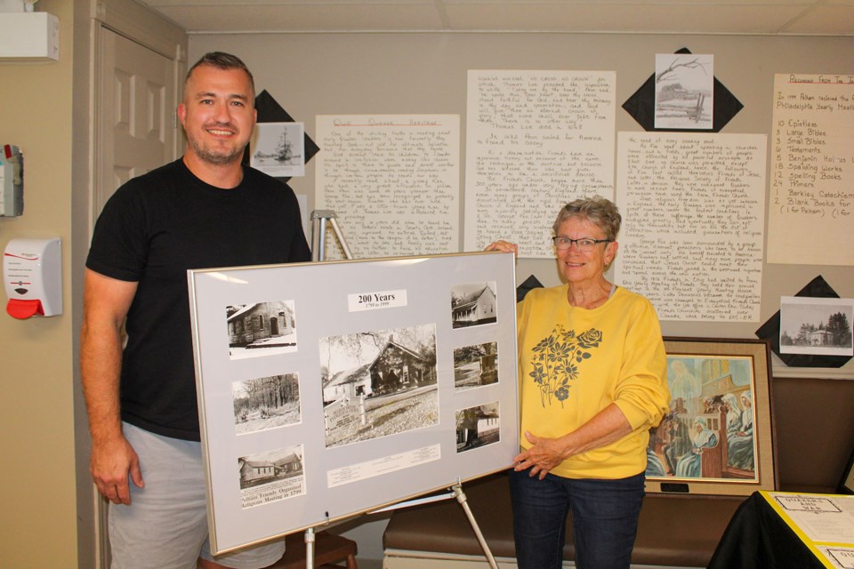 Pastor Jon Warner and 225th anniversary celebration member Sharon Vizbulis show off some of the items detailing the history of the Pelham Friends Church. The items – including photographs, newspaper clippings and artifacts – will part of a display at anniversary celebrations being held this weekend.