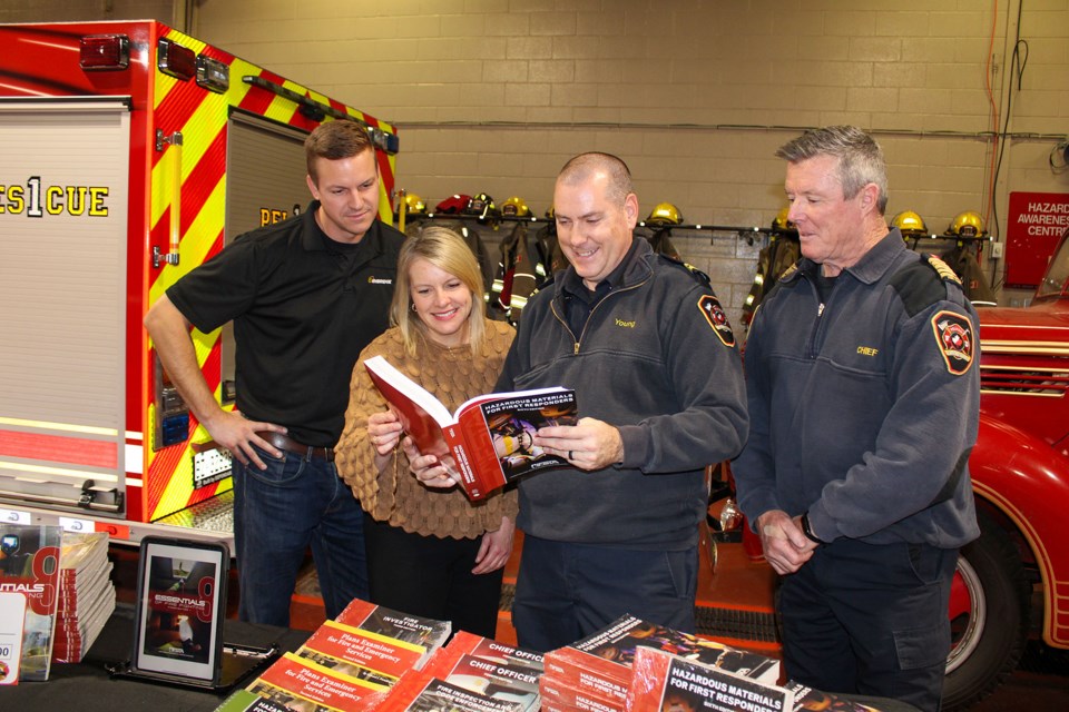 Erik Bishop, operations manager, Hamilton/Niagara for Enbridge, left, looks over the training manuals purchased by the Pelham Fire Department with the help of a $5,000 grant from Enbridge Gas’ Safe Community Project Assist program. With Bishop are Julie Alexander, senior advisor, municipal and stakeholder affairs and community engagement for Enbridge, Greg Young, training officer for the Pelham Fire Department and Chief Bob Lymburner.