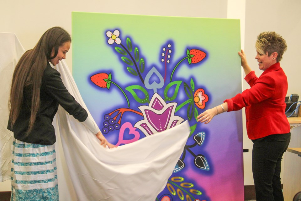 Shyann Jenkins, left, Indigenous Community Outreach and Engagement for Niagara Health’s Indigenous Health Services Team, helps unveil Delbert JayR Jonathan’s work which will be displayed in mental health outpatient units in Niagara Health’s Welland site. Helping Jenkins is Robin Crown, Niagara Health’s clinical manager of outpatient mental health and addictions.